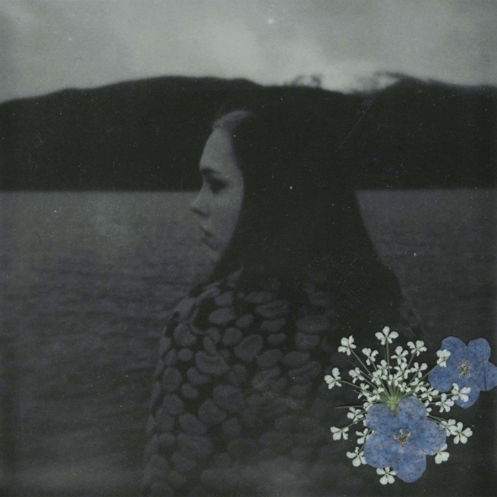 Black and white portrait of a woman with pressed flowers.