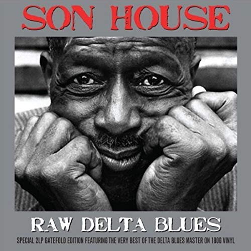 Black and white close-up portrait of Son House with hands resting under his chin.