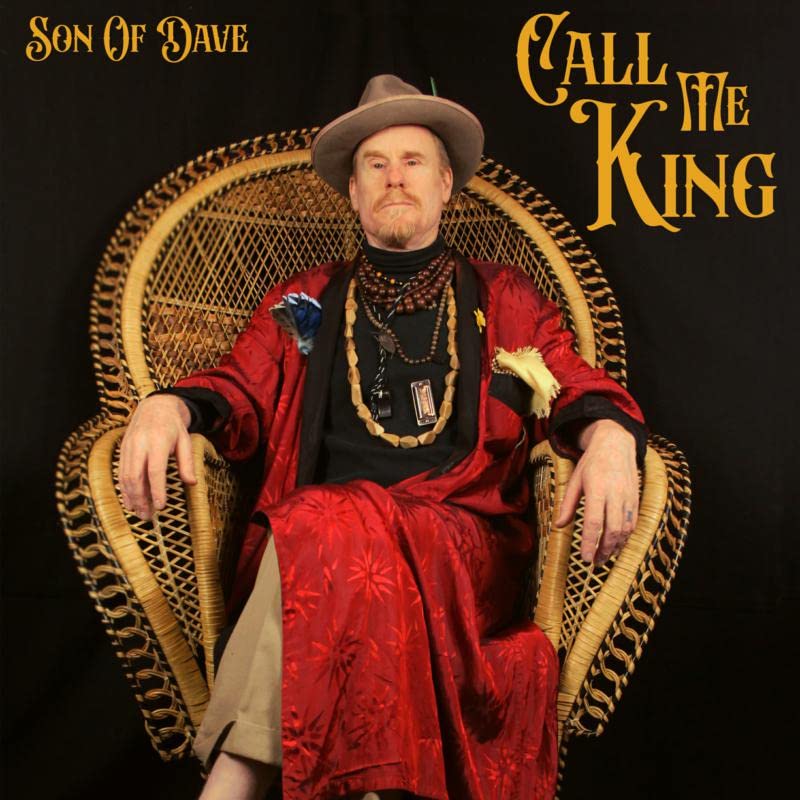 CD cover: Man in hat and red robe seated in a chair.
