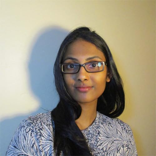Woman with dark hair and glasses, looking directly at the camera.