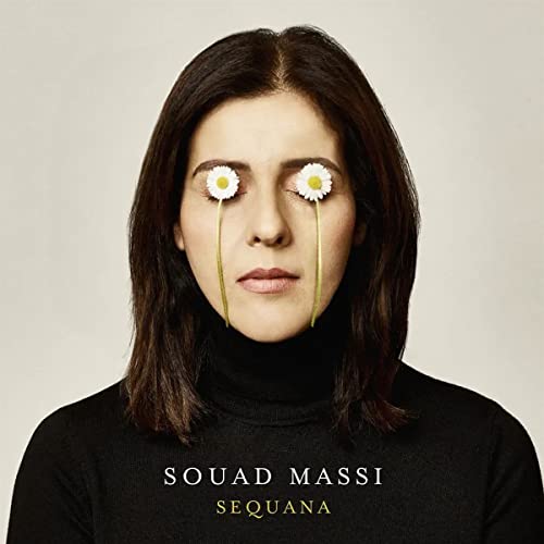 Souad Massi with closed eyes covered by daisies on the Sequana album cover.