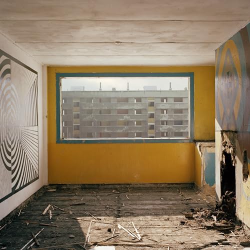 CD cover: room with window overlooking concrete buildings, abstract art.