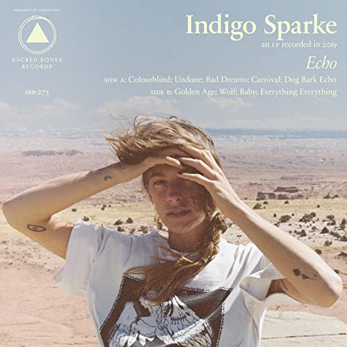 Vinyl record cover featuring a person with hand to face, desert background.