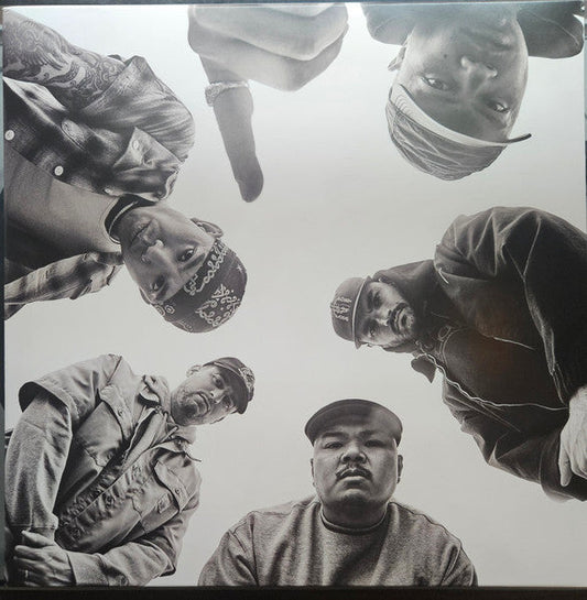 Low-angle, black-and-white photo of five men looking down toward the camera.