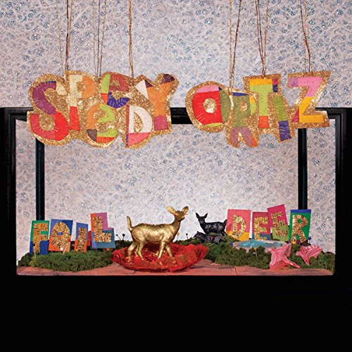"Album cover with 'Speedy Ortiz' banner, gold deer, and records on a shelf."