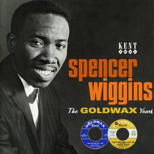 "Black-and-white portrait of Spencer Wiggins with vinyl records on a gray background."