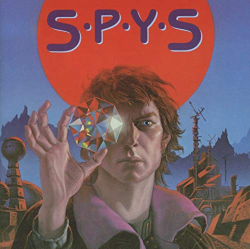 CD cover for "Spys" featuring a man holding a geometric crystal.