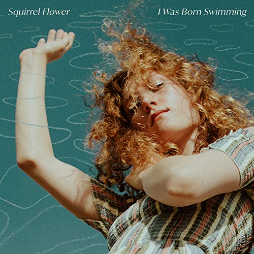 A person with curly red hair poses against a teal background with drawn ripples.