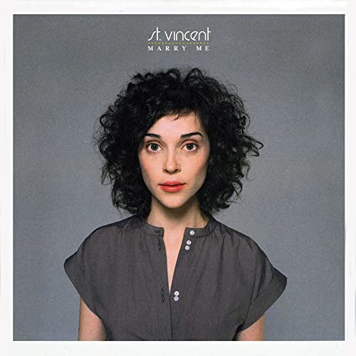 CD cover featuring a woman with curly black hair against a gray background.