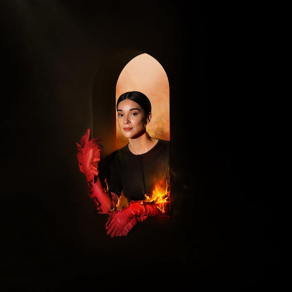 St. Vincent portrait framed by an archway, with red hands and flames.