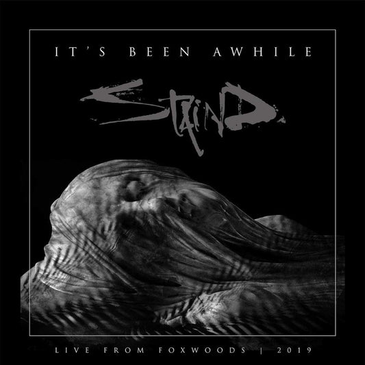 Staind album cover: hooded figure with arms outstretched, dark background.