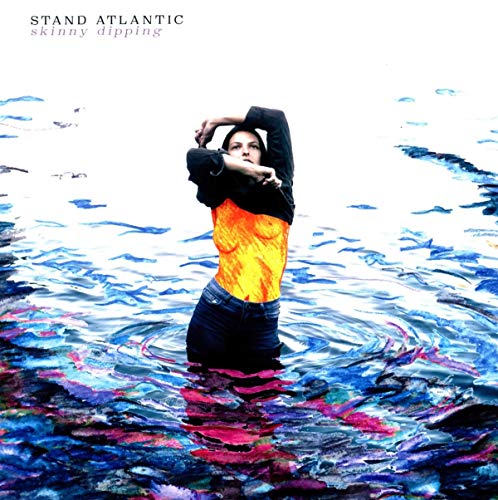 Woman in water, partially submerged, wearing jeans and a two-tone top.