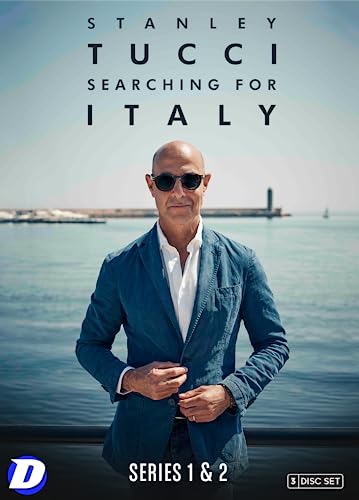 Stanley Tucci wearing sunglasses and a blue blazer in front of a harbor.