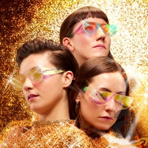 Three women wearing iridescent sunglasses against a gold glitter background.