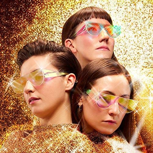 Three women wearing iridescent sunglasses against a gold glitter background.