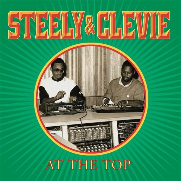 Album cover for Steely & Cleevie’s “At The Top” featuring two men and equipment.