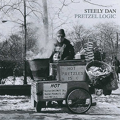 Black and white image of a street vendor selling pretzels and chestnuts in winter.