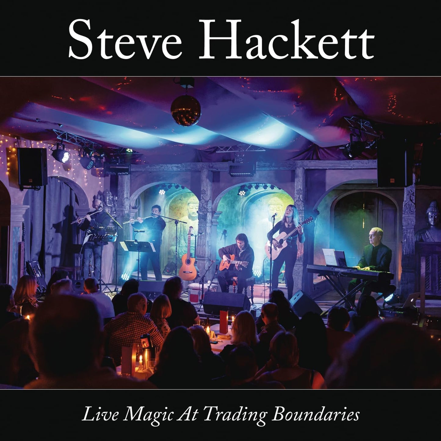 Steve Hackett live band performing on stage with audience, dark venue.