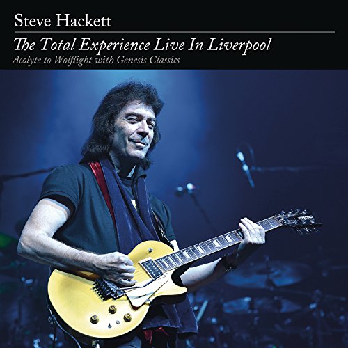 Steve Hackett playing a yellow electric guitar on stage against a dark blue background.