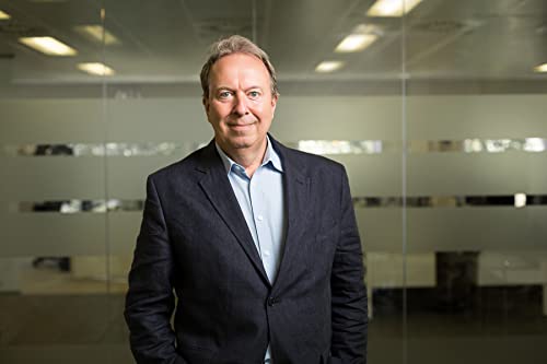 Portrait of a middle-aged man in a suit, indoors with glass walls.