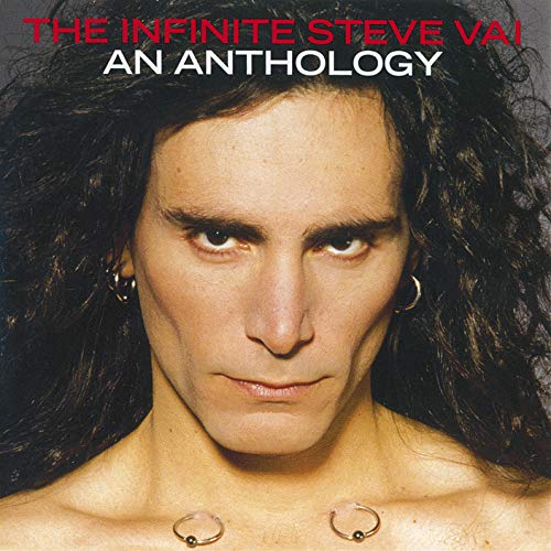 Close-up portrait of Steve Vai with long dark hair and chest piercings.