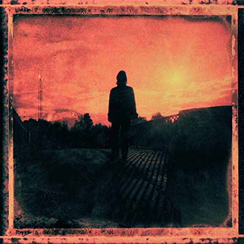 Silhouette of a person against a fiery orange and red sunset.