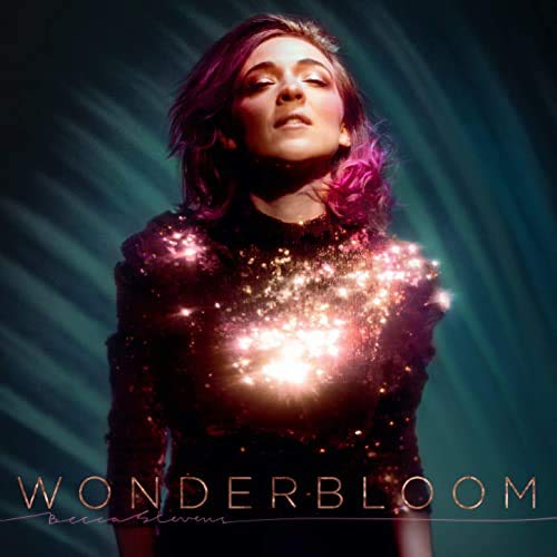 The alt text for the image is: "Woman in sparkly black dress with glowing lights on her chest."