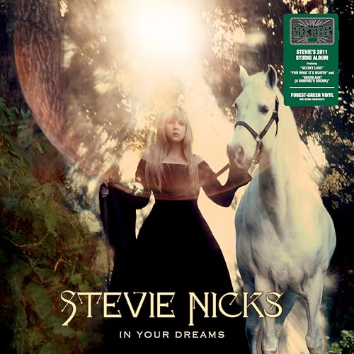 Stevie Nicks stands in a forest next to a white horse on this album cover.