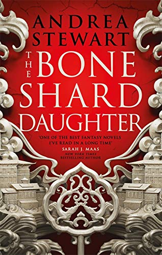 Book cover: red background, ornate silver frame, and city illustration.
