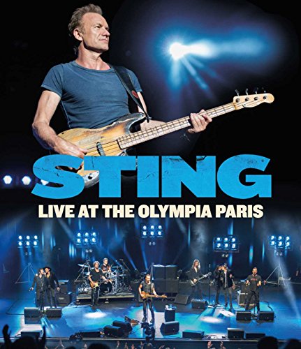 Sting playing bass guitar onstage with his band at a concert.