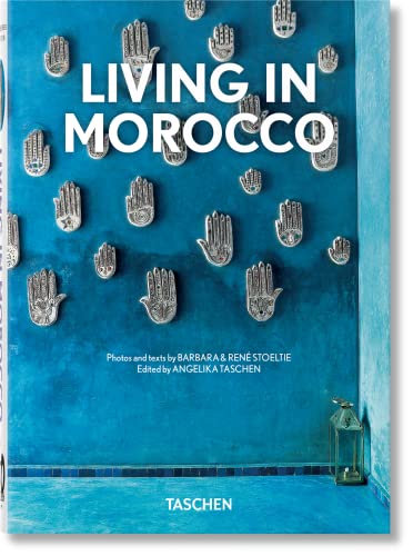 Book cover titled Living in Morocco featuring silver hamsa hands on a blue wall.