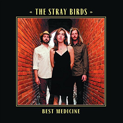 Album cover with three people standing in a brick alleyway, black background.
