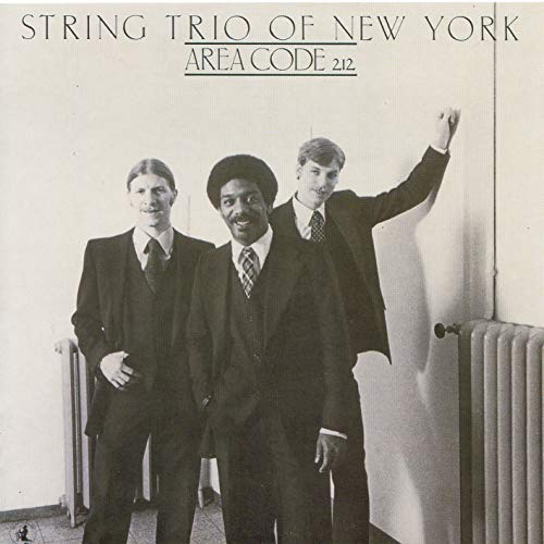 CD cover featuring three men in suits, standing by a door.