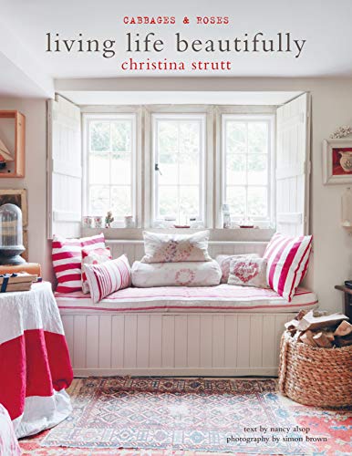 Book cover with a window seat decorated with red and white pillows.