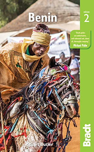 A man in traditional golden robes rides a horse decorated with colorful ribbons.