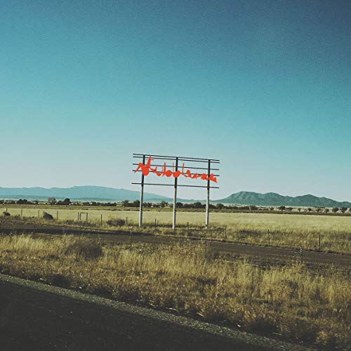 The image depicts a billboard with red cursive text against a rural landscape. For accessibility purposes, a suitable alt text could be: "Billboard with 'Stubblebum' in red cursive script, in a rural landscape."