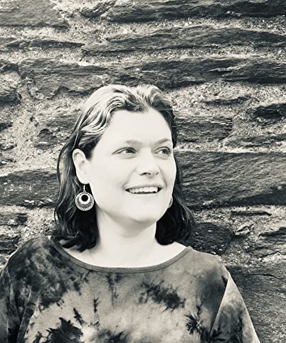 Black and white portrait of a smiling woman with earrings.