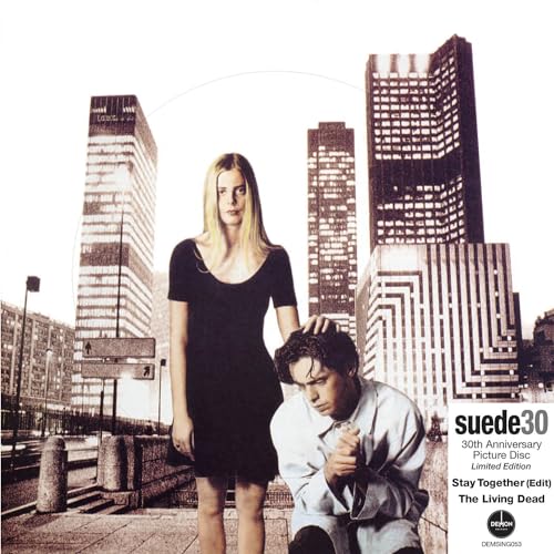 Suede album cover: two people in front of city skyscrapers.