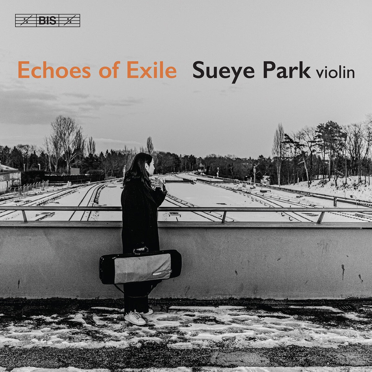 CD cover: Woman with violin case stands near a railway track.