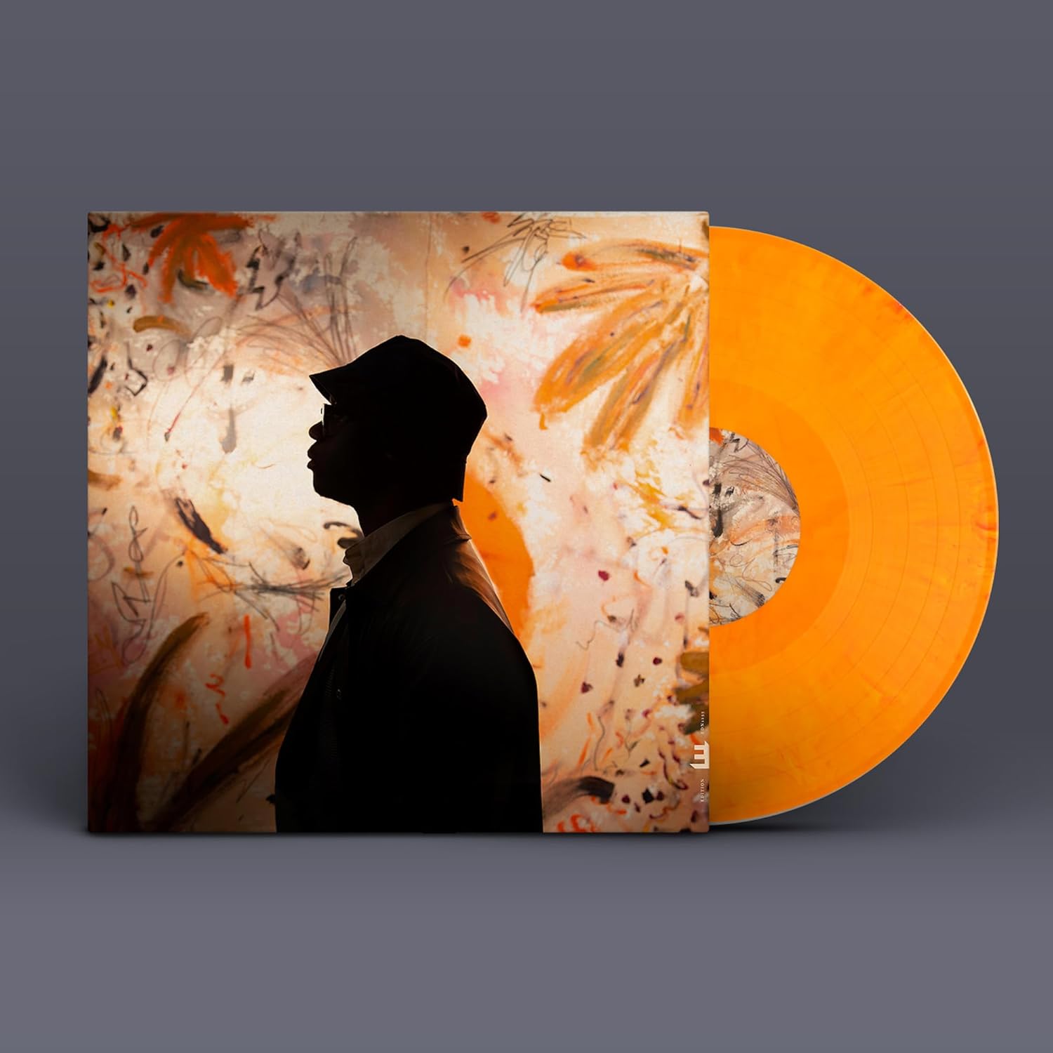 Vinyl record with album cover featuring a silhouetted man and abstract art.
