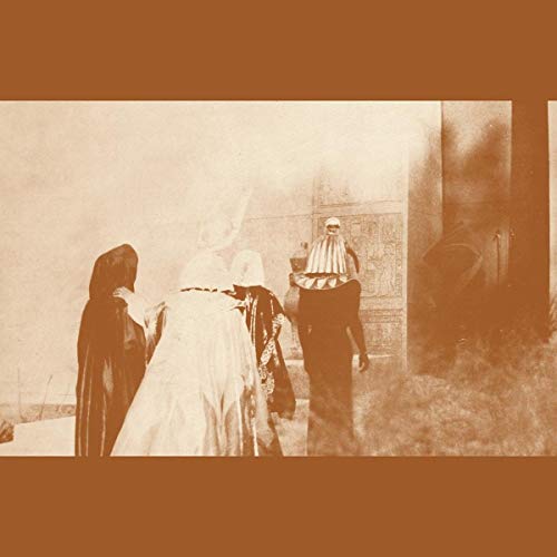 Vintage-style photo of three hooded figures before an ornate doorway.