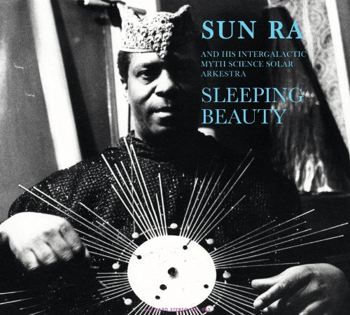 Black and white photo of Sun Ra holding a solar disk with lines radiating.