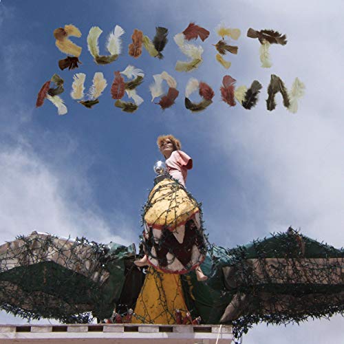 Album cover: Sunset Rubdown, featuring a woman atop a dragon sculpture.