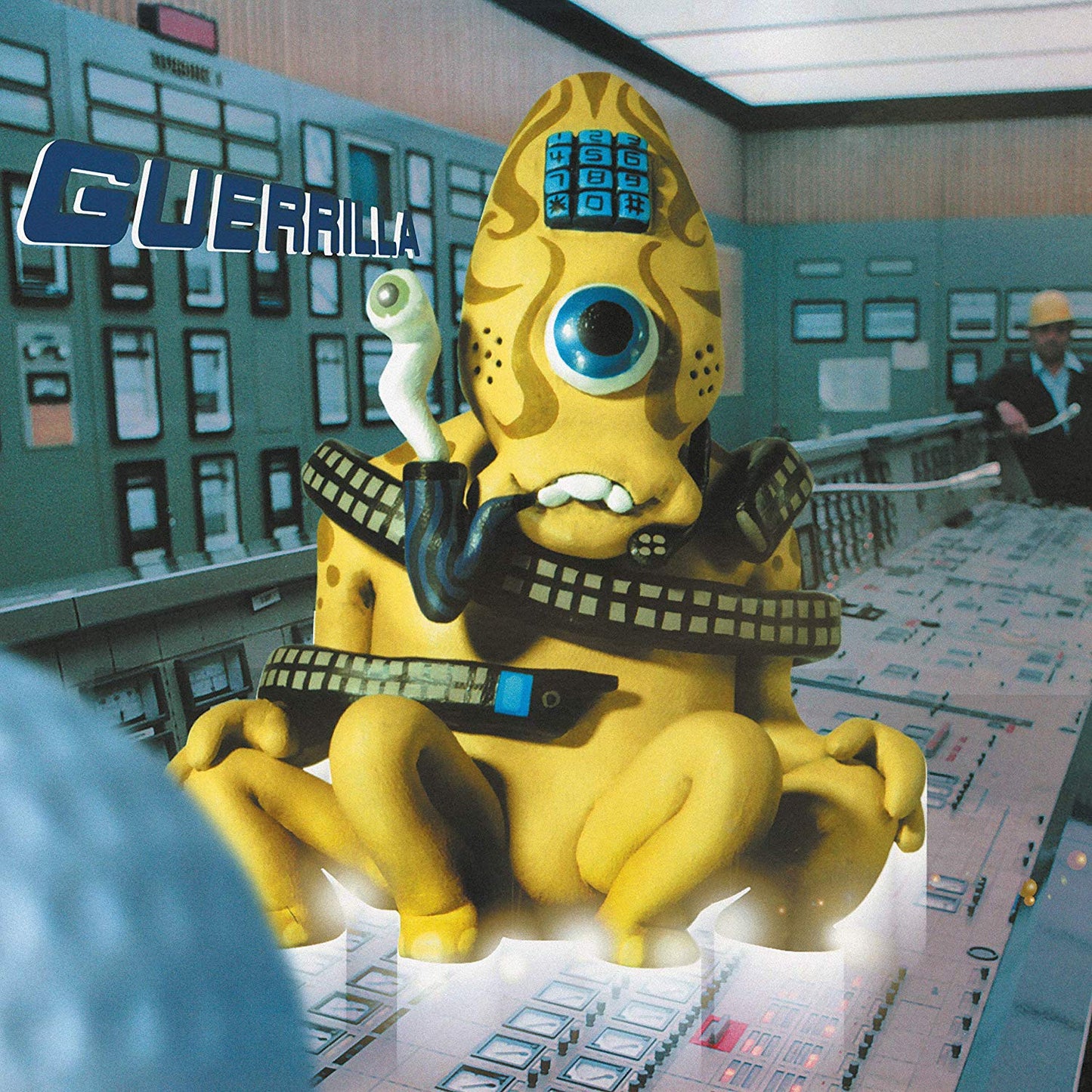 "CD album cover featuring a cartoonish yellow creature in a control room."