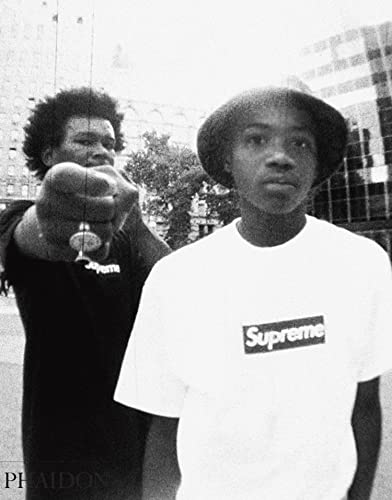 Black and white photo of two men wearing Supreme box logo t-shirts outdoors.