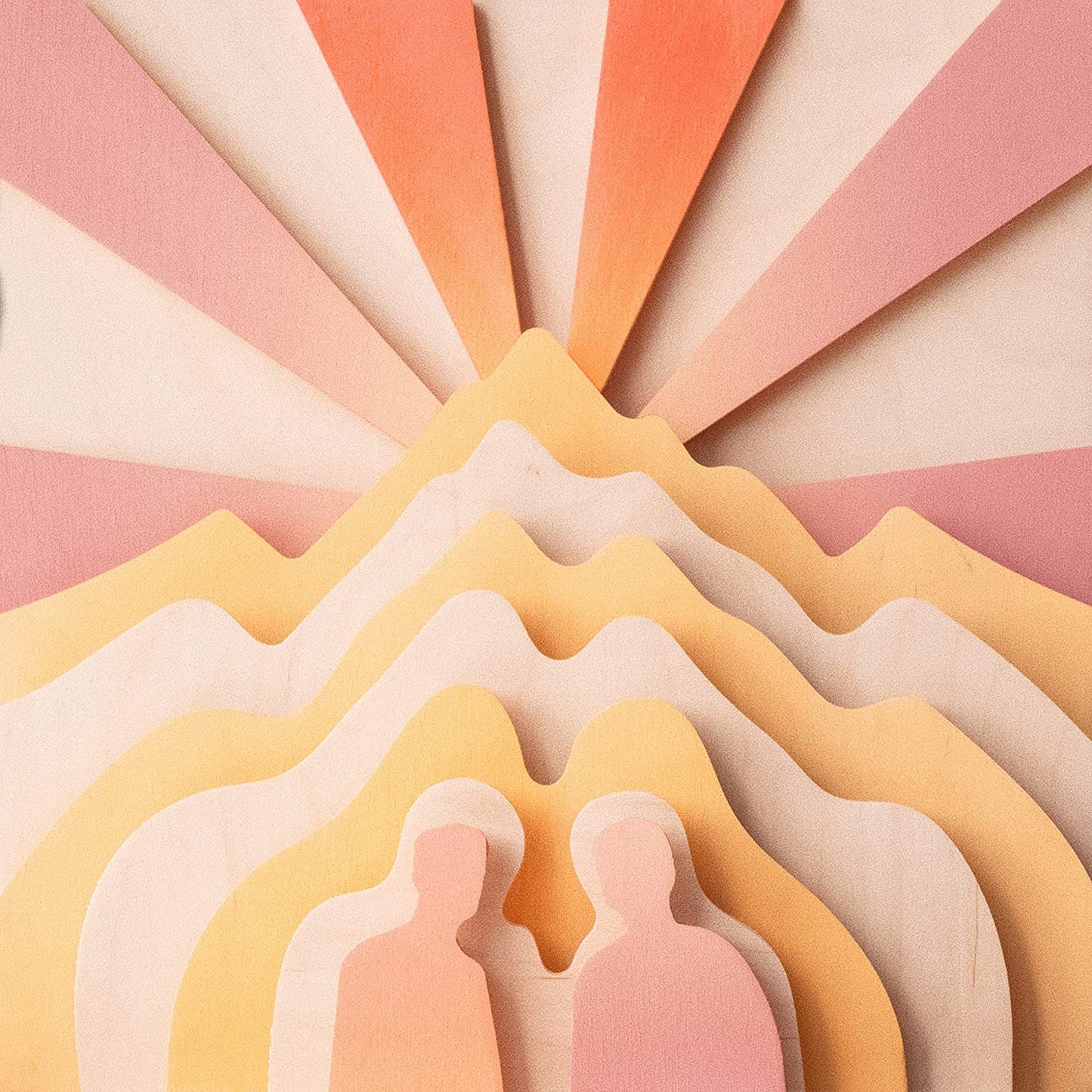 Layered paper art depicting mountains and silhouetted figures.