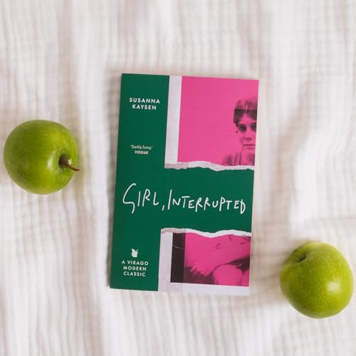 Girl, Interrupted book cover between two green apples on a white textured background.