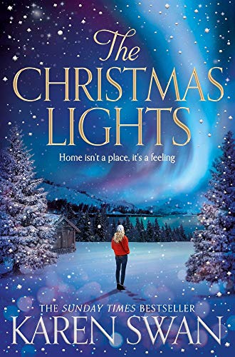 A woman in a red jacket stands in a snowy landscape under northern lights.