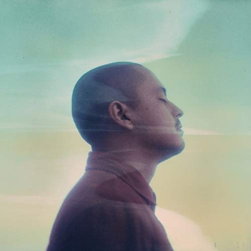 The image depicts a man in profile, with a blurred, ghostly effect. Alt text: Man in profile with blurred, ghostly effect against a cloudy background.