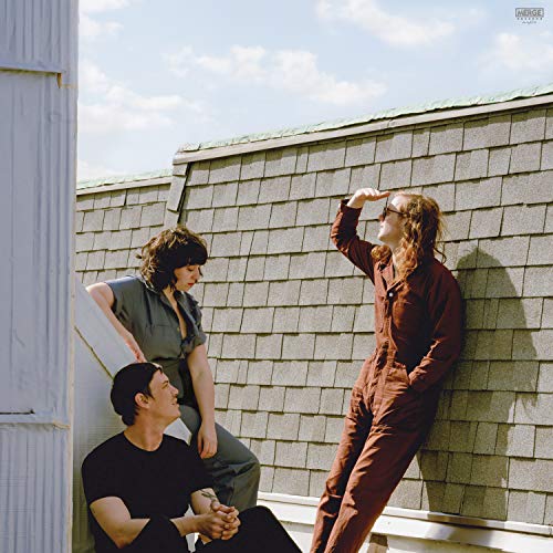 Three people on a shingled roof under a bright blue sky.